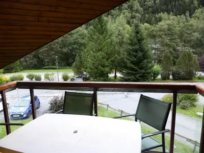 a white table and chairs on a balcony with a view of a car at Résidence L'enclave - Enclave J717 MAE-5744 in Les Contamines-Montjoie