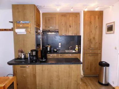 a kitchen with wooden cabinets and a counter top at Résidence L'enclave - Enclave J717 MAE-5744 in Les Contamines-Montjoie