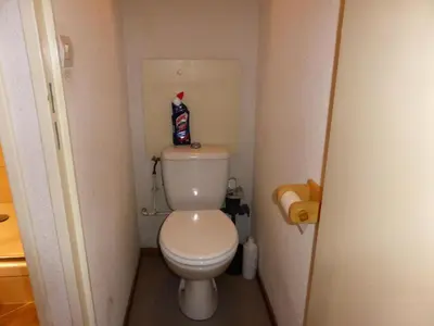 a bathroom with a toilet with a bottle of coke on top at Résidence L'enclave - Enclave J717 MAE-5744 in Les Contamines-Montjoie