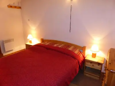 a bedroom with a red bed and two lamps on tables at Résidence L'enclave - Enclave J717 MAE-5744 in Les Contamines-Montjoie