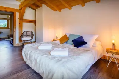a bedroom with a large bed with two pillows on it at Chalet Les Vosnes - OVO Network in Domancy
