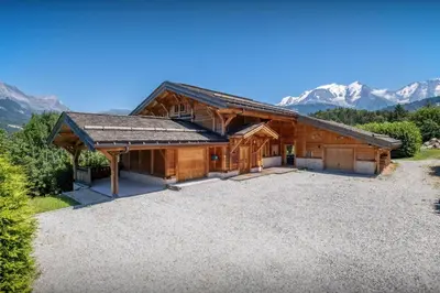 a house with a large driveway in front of mountains at Chalet Les Vosnes - OVO Network in Domancy