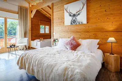 a bedroom with a bed with a deer picture on the wall at Chalet Les Vosnes - OVO Network in Domancy