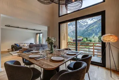a dining room with a table and chairs and a couch at La Cordee 221 Penthouse - Chamonix All Year in Chamonix-Mont-Blanc