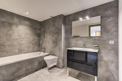 a bathroom with a tub and a toilet and a sink at La Cordee 221 Penthouse - Chamonix All Year in Chamonix-Mont-Blanc