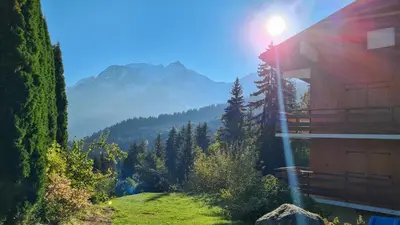 a house on a hill with a view of a mountain at Charmant Studio vue montagne - ski, piscine, tennis, randonnées in Saint-Gervais-les-Bains