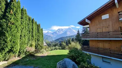 a view of a house and a field with trees at Charmant Studio vue montagne - ski, piscine, tennis, randonnées in Saint-Gervais-les-Bains