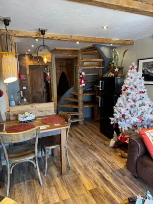 a living room with a christmas tree and a table at le coup de coeur in Les Houches