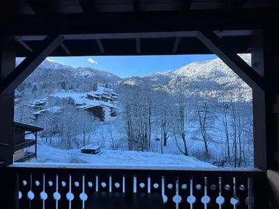 a view of a snowy mountain from a window at le coup de coeur in Les Houches