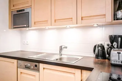 a kitchen with a sink and a microwave at Vue panoramique sur les montagnes plein Sud - T2 Skis aux pieds, Piscine & Spa in Flaine