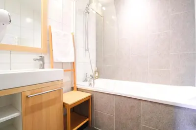 a bathroom with a tub and a sink and a bath tub at Vue panoramique sur les montagnes plein Sud - T2 Skis aux pieds, Piscine & Spa in Flaine