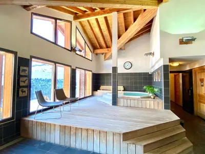 a large room with a jacuzzi tub and chairs at Vue panoramique sur les montagnes plein Sud - T2 Skis aux pieds, Piscine & Spa in Flaine