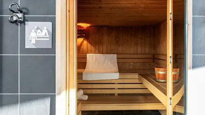 a sauna with a bench in the corner of a room at Vue panoramique sur les montagnes plein Sud - T2 Skis aux pieds, Piscine & Spa in Flaine