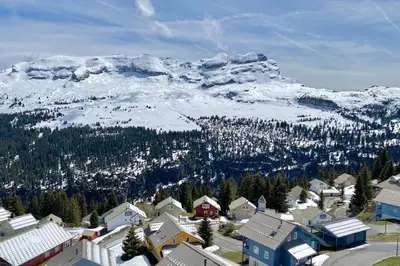 a town with a snow covered mountain in the background at Vue panoramique sur les montagnes plein Sud - T2 Skis aux pieds, Piscine & Spa in Flaine