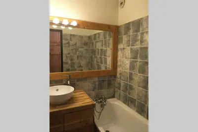 a bathroom with a sink and a tub and a mirror at Charmant appartement, centre ville, vue Mont-Blanc in Chamonix-Mont-Blanc