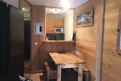 a kitchen with a wooden table in a room at Charmant appartement, centre ville, vue Mont-Blanc in Chamonix-Mont-Blanc