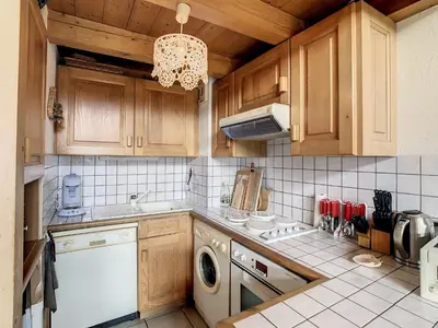 a kitchen with wooden cabinets and a washer and dryer at Duplex cosy à deux pas des pistes avec parking à Combloux - FR-1-560-80 in Combloux