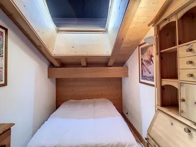 a small bedroom in a tiny house with a skylight at Duplex cosy à deux pas des pistes avec parking à Combloux - FR-1-560-80 in Combloux