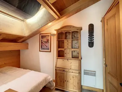 a bedroom with a bed and a snowboard on the wall at Duplex cosy à deux pas des pistes avec parking à Combloux - FR-1-560-80 in Combloux