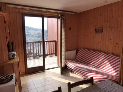 a room with a bed and a balcony with a view at Résidence Les Loges - Loges 11 MAE-4364 in Saint-Gervais-les-Bains