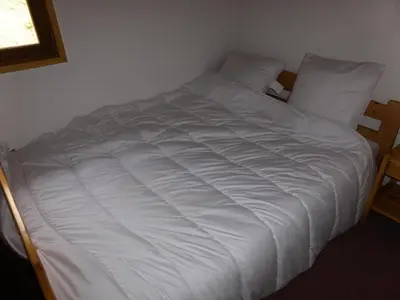 a white bed in a room with a window at Résidence Les Loges - Loges 11 MAE-4364 in Saint-Gervais-les-Bains