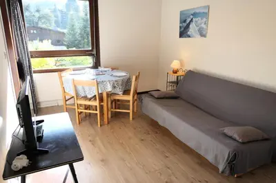 a bedroom with a bed and a table and a window at Résidence Castel Des Roches C - Castel des Roches A27 MAE-4374 in Saint-Gervais-les-Bains