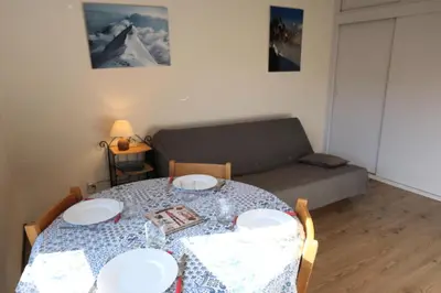 a dining room table with two plates and a couch at Résidence Castel Des Roches C - Castel des Roches A27 MAE-4374 in Saint-Gervais-les-Bains