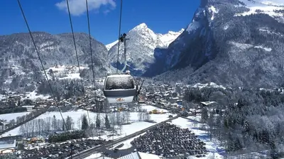 a ski lift in the mountains with a snow covered mountain at Samoëns 1600 les cimes in Samoëns