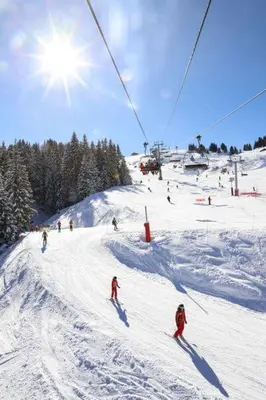 a group of people skiing down a snow covered ski slope at Samoëns 1600 les cimes in Samoëns