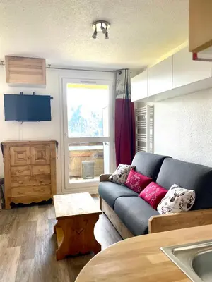 a living room with a couch and a window at Samoëns 1600 les cimes in Samoëns