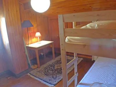 a bedroom with a bunk bed and a table with a lamp at Chalet Gentiane - un lieu idéal pour des vacances en famille ou entre amis - FR-1-629-88 in Samoëns