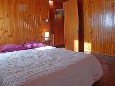 a bed in a room with wooden walls and wooden floors at Chalet Gentiane - un lieu idéal pour des vacances en famille ou entre amis - FR-1-629-88 in Samoëns