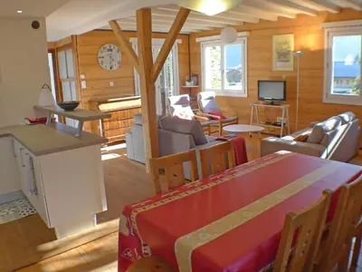 a living room with a table and chairs and a tv at Chalet Gentiane - un lieu idéal pour des vacances en famille ou entre amis - FR-1-629-88 in Samoëns