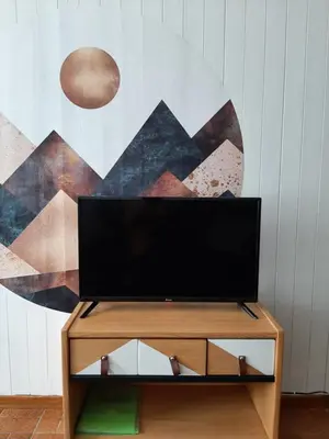 a tv sitting on a stand in front of a wall at Appartement avec terrasse centre samoens in Samoëns