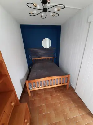 a bedroom with a wooden bed with a ceiling fan at Appartement avec terrasse centre samoens in Samoëns