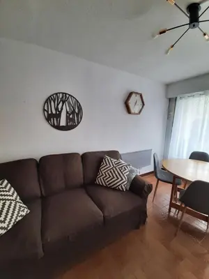 a living room with a brown couch and a table at Appartement avec terrasse centre samoens in Samoëns