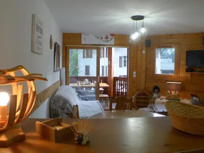 a child sitting in a living room with a table at Cosy, 3 pièces au centre, animaux admis, parking - FR-1-629-89 in Samoëns