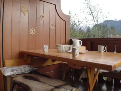 a wooden table with a dog sitting next to it at Cosy, 3 pièces au centre, animaux admis, parking - FR-1-629-89 in Samoëns