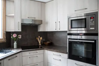 a kitchen with white cabinets and a microwave at Le Beausite C Apartment - Chamonix All Year in Chamonix-Mont-Blanc