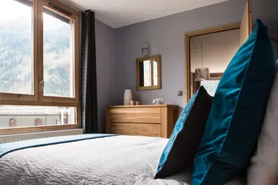 a bedroom with a bed with a large window at Le Beausite C Apartment - Chamonix All Year in Chamonix-Mont-Blanc