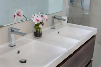a bathroom sink with a vase of flowers on it at Le Beausite C Apartment - Chamonix All Year in Chamonix-Mont-Blanc