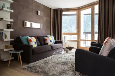 a living room with a couch and a large window at Le Beausite C Apartment - Chamonix All Year in Chamonix-Mont-Blanc