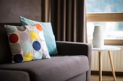 a couch with a pillow on it with a window at Le Beausite C Apartment - Chamonix All Year in Chamonix-Mont-Blanc
