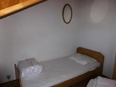 a small bedroom with a bed with a mirror on the wall at Résidence Combettes - Les Combettes D258 MAE-0324 in Les Contamines-Montjoie