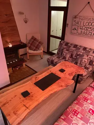 a wooden bed in a room with a couch at Loge des rêveurs in Les Carroz d'Araches