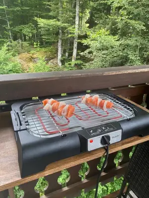 a grill with hot dogs on it on a deck at Loge des rêveurs in Les Carroz d'Araches