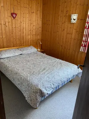 a bedroom with a bed in a wooden wall at Loge des rêveurs in Les Carroz d'Araches