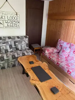 a room with a bed and a table and a couch at Loge des rêveurs in Les Carroz d'Araches