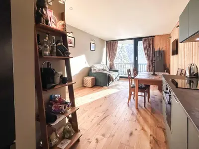 a kitchen and living room with a table and a dining room at Next to the pistes, 1-bedroom family apartment in Flaine