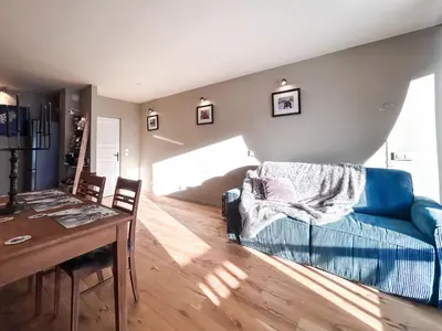 a living room with a blue couch and a table at Next to the pistes, 1-bedroom family apartment in Flaine